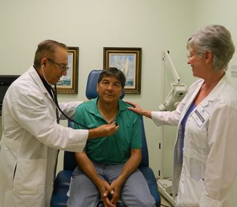Neighborhood Clinic Impact Gallery: Doctor and Nurse Volunteers assisting a patient